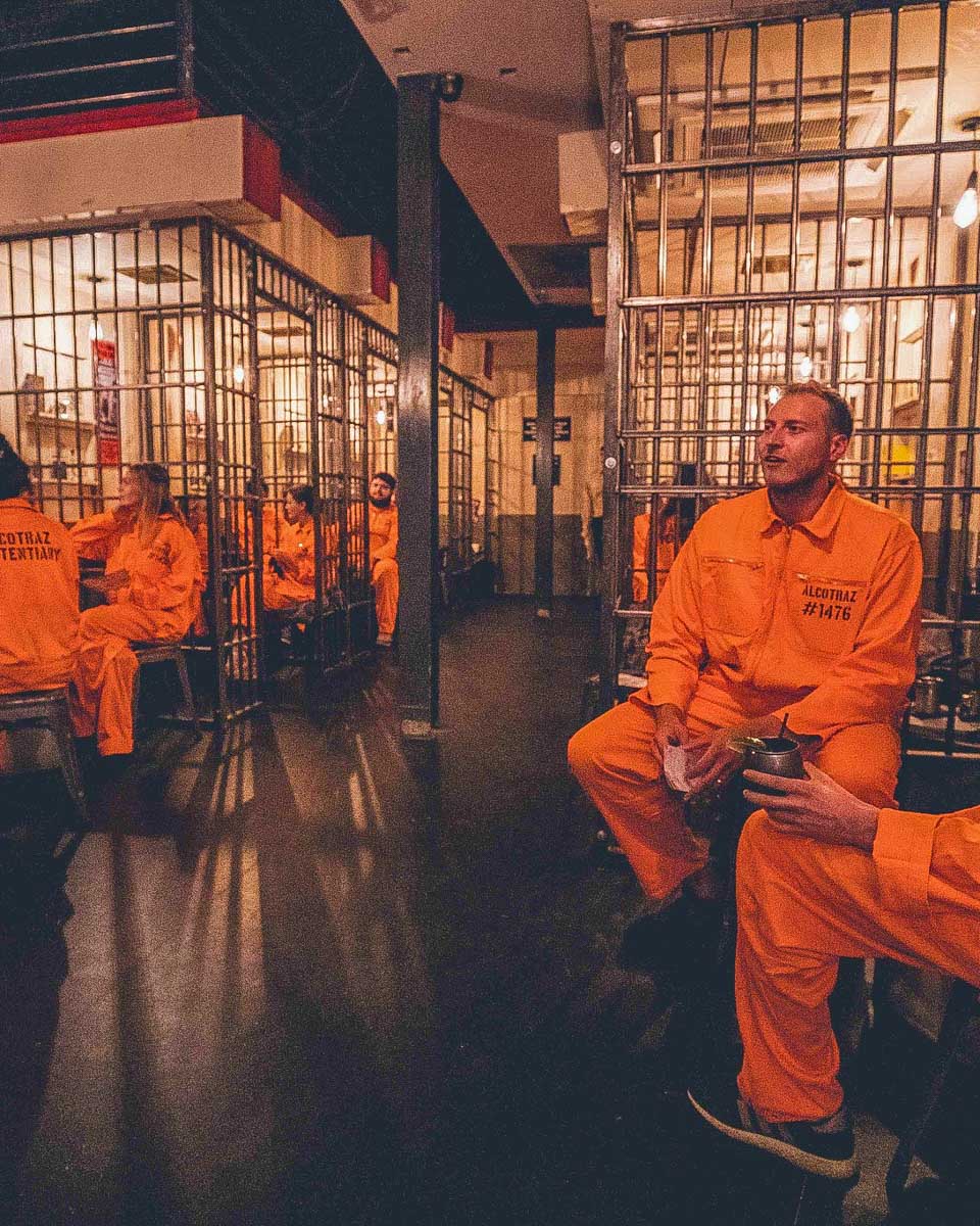 Alcotraz Manchester Cell Block Three-Four people sit in cells at a bar in Manchester UK