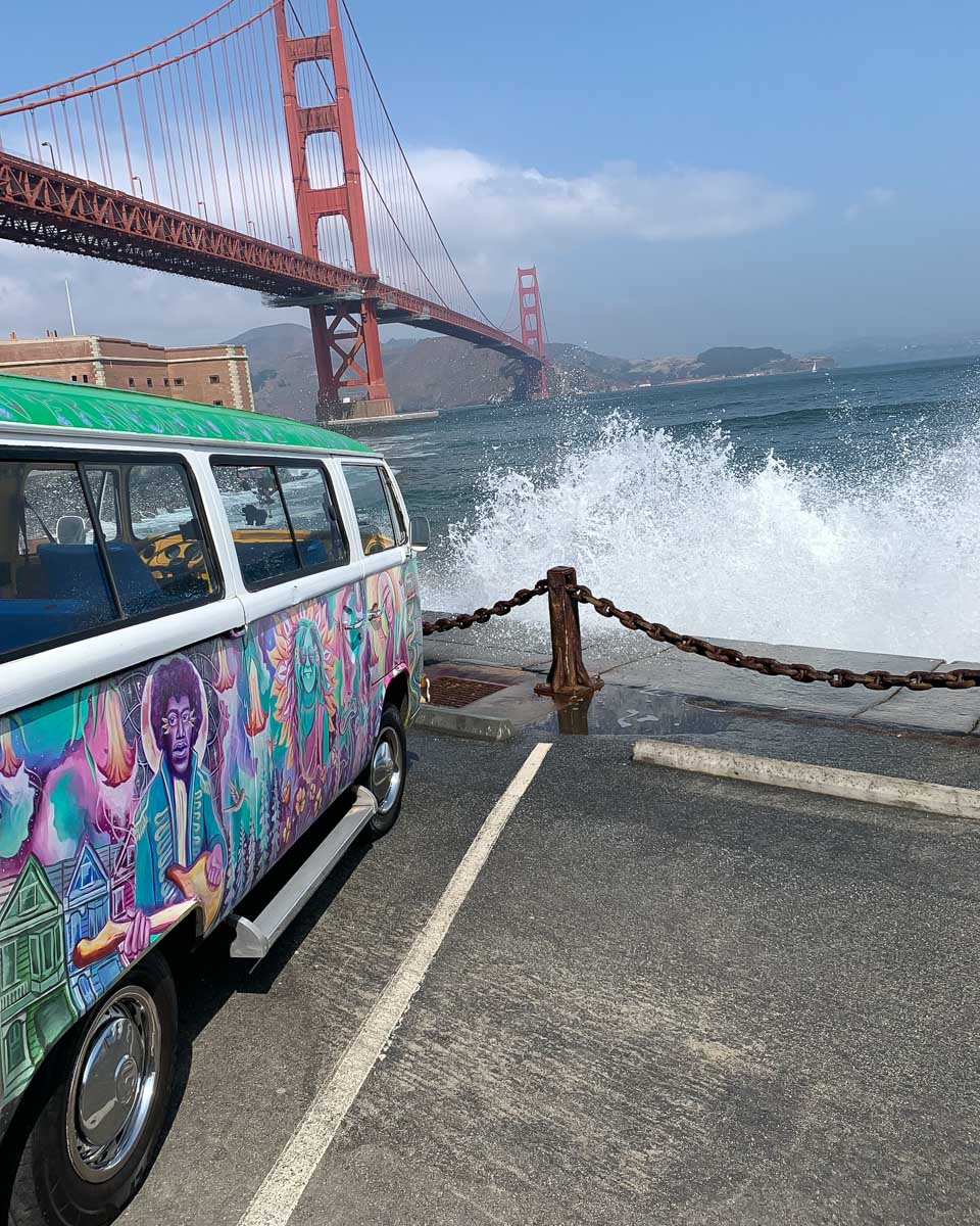a colorful vw van in front of the Golden Gate Bridge on a tour with San Francisco Love Tours