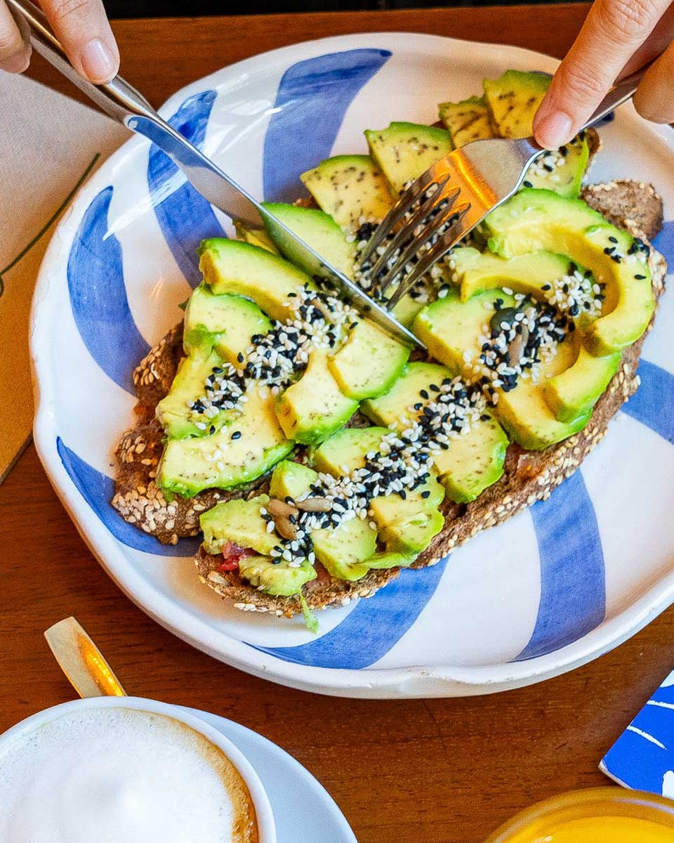 A pereson eats avocado toast at Filo Seville