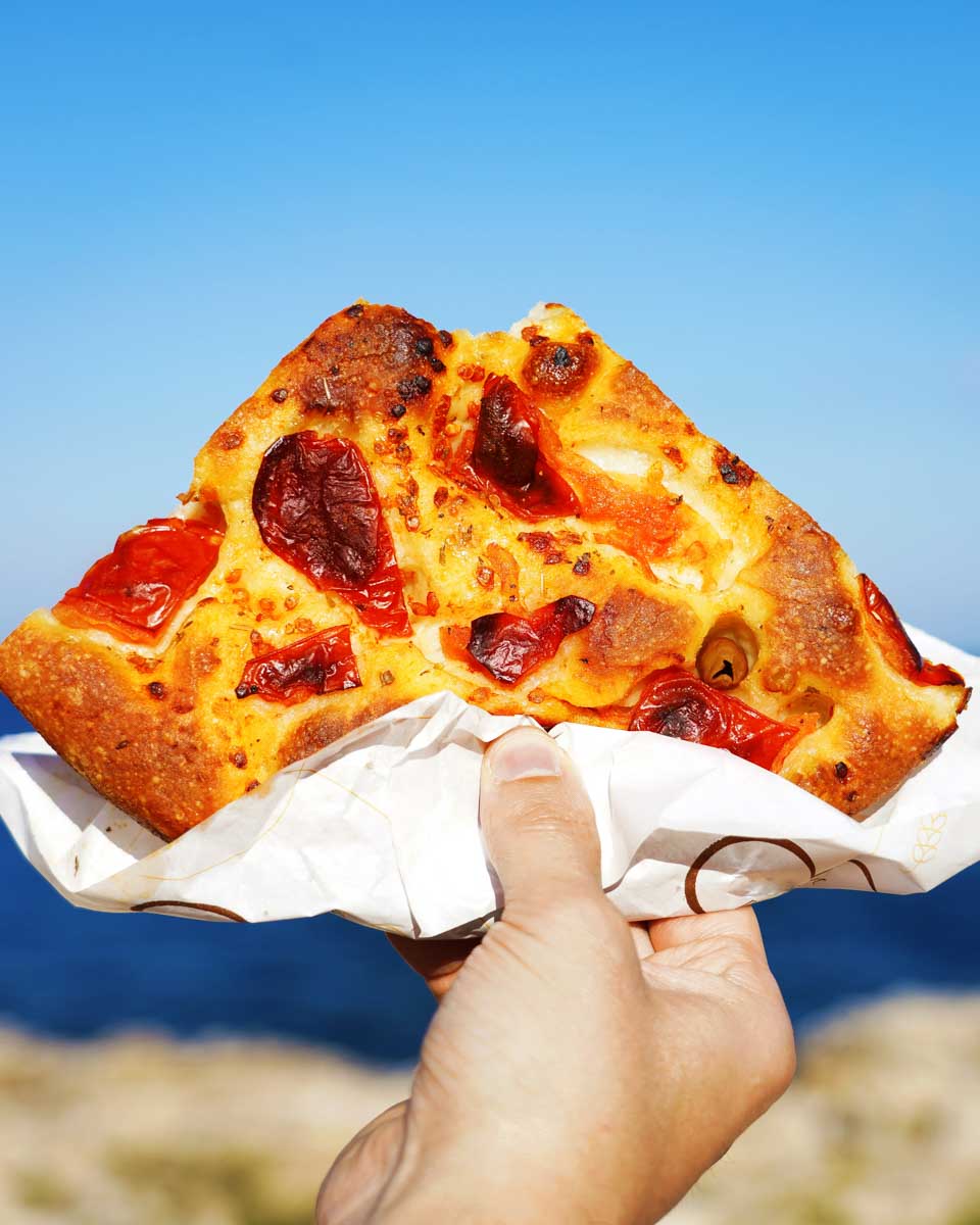 A slice of pizza eaten on a bike tour of Bari Italy
