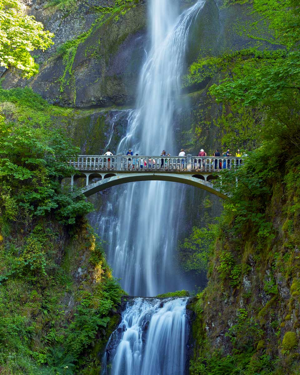People standing at multnomah falls on a tour from Portland Oregon
