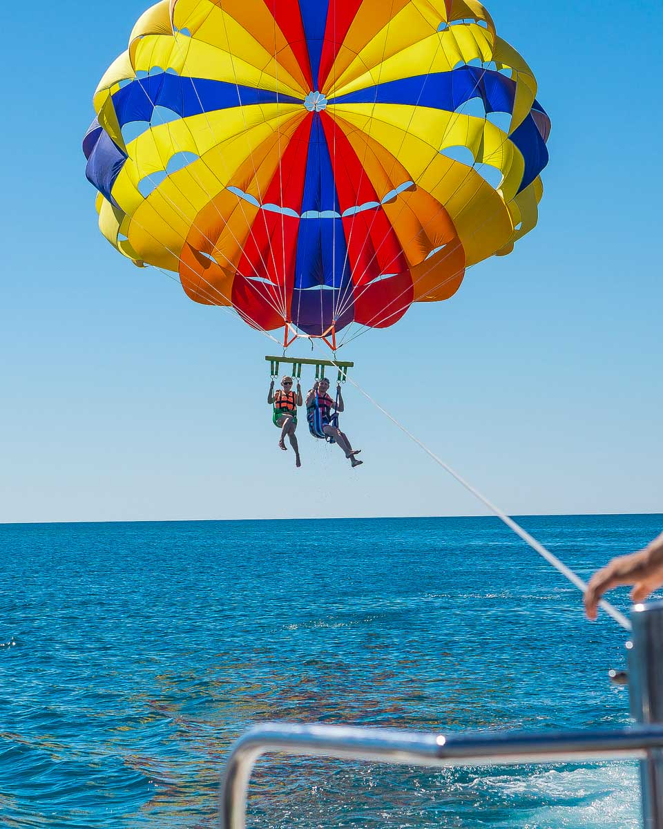 Two-people-parasail-over-the-ocean-in-Oahu-Hawaii near Honolulu