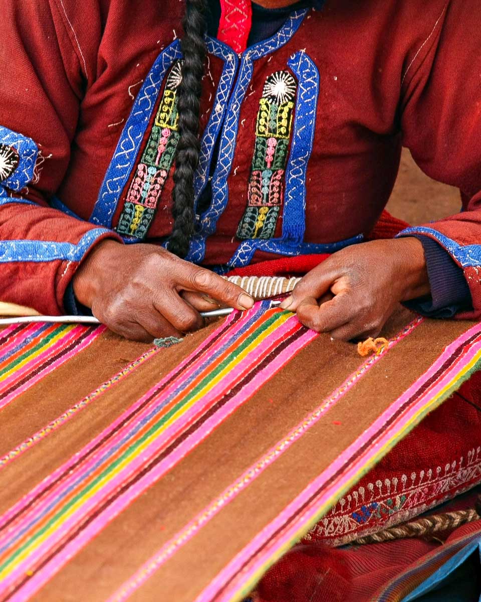 A-local-woman-makes-a-blanket-in San Blas Plaza Market Cusco Peru