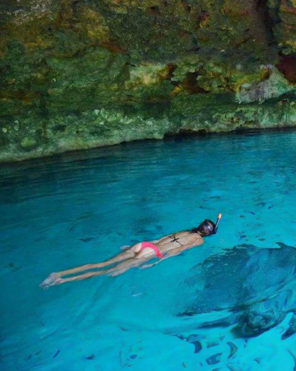Bailey swims in a cenote on a tour from Tulum Mexico