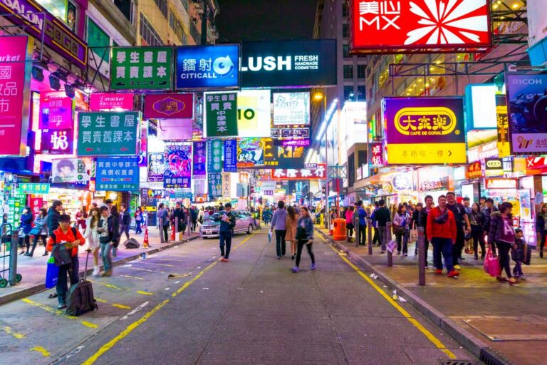 People walk through a shopping street at night in Hong Kong China