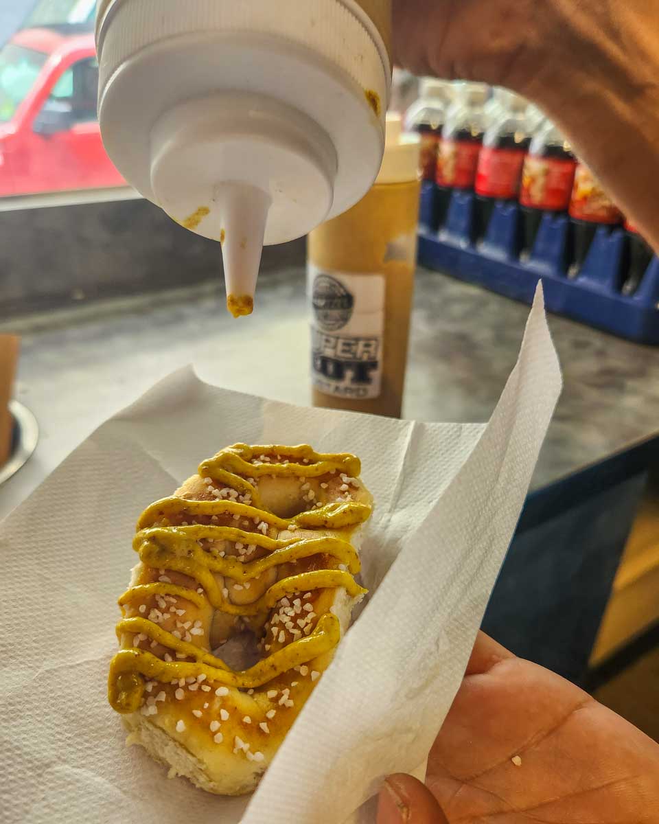 Pouring-mustard-on-a-fresh-pretzel-in Chicago Illinois on a food tour