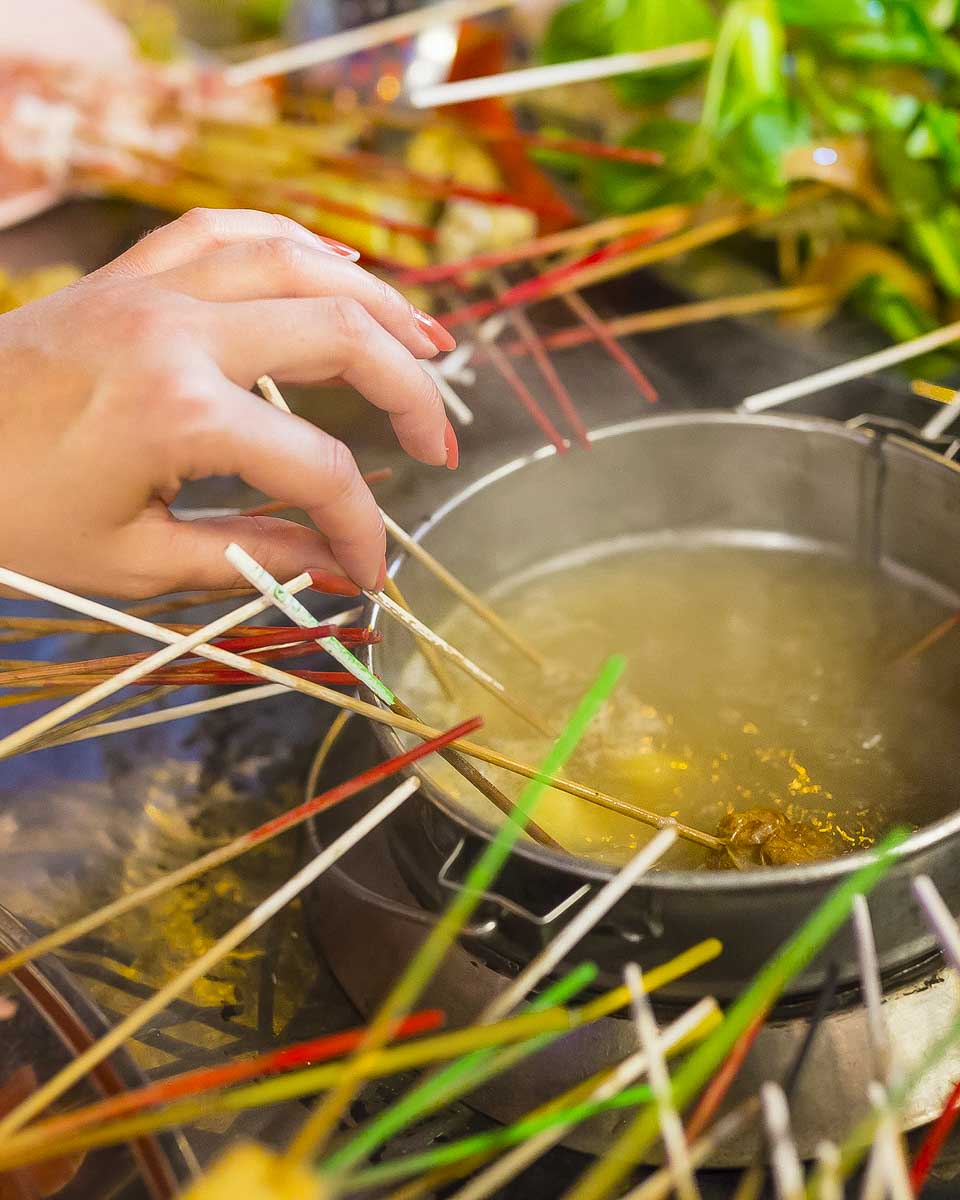 A woman eats food on a street food tour tour in Kuala Lumpur Malaysia