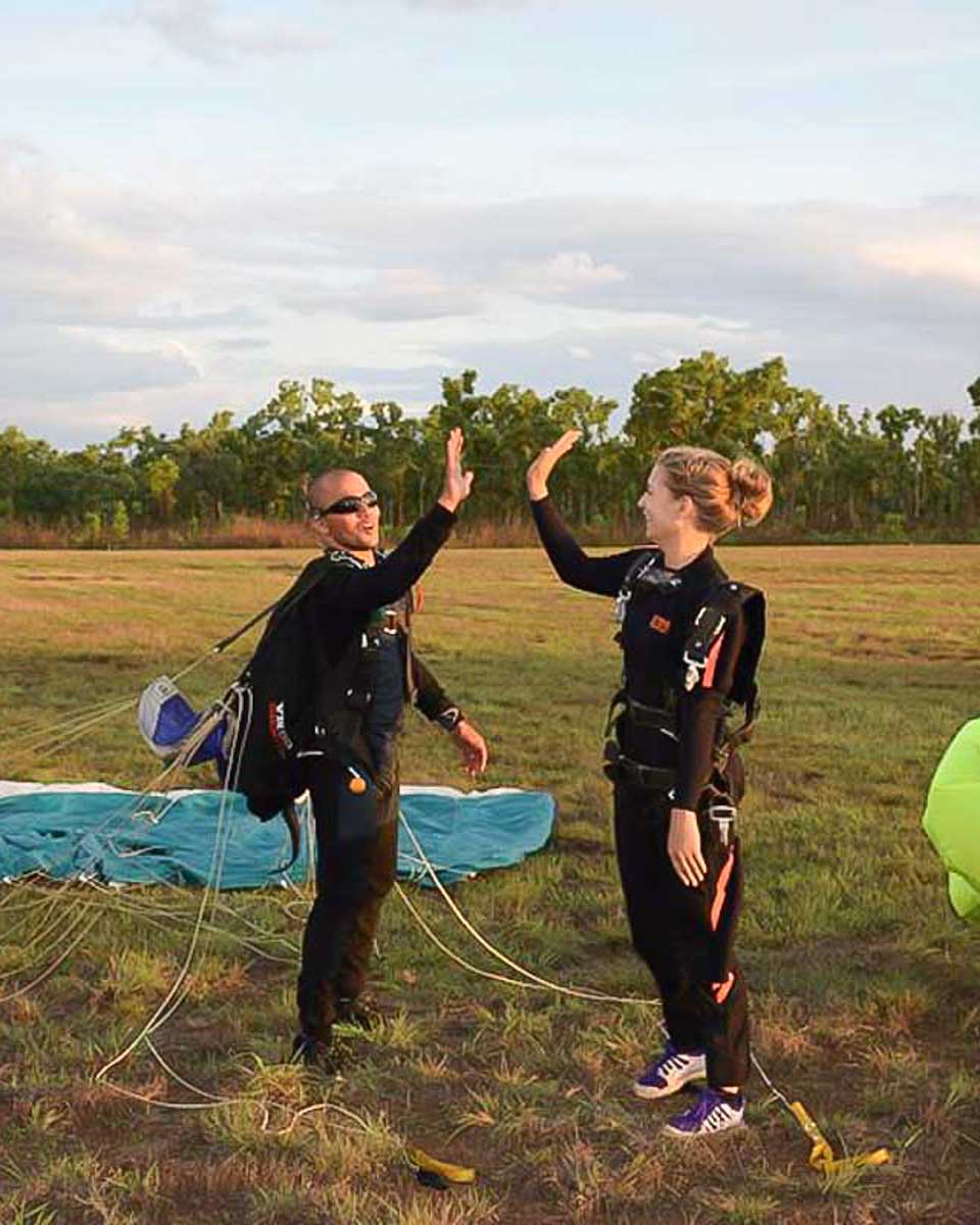 Bailey high fiving her instructor after skydiving in Sao Paulo