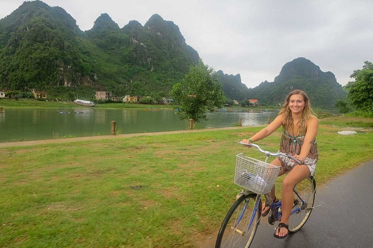 Bailey rides a bike through the countryside in Vietnam