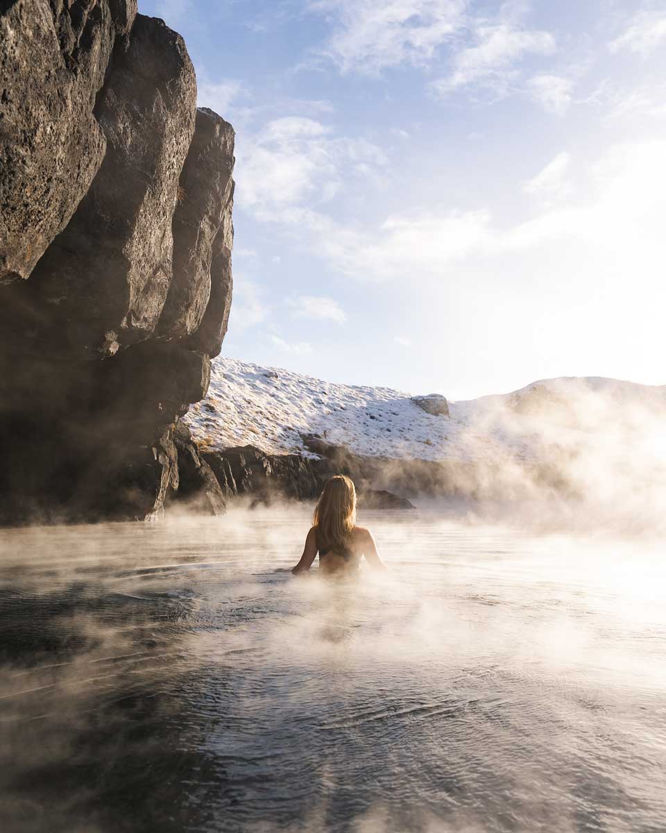 A woman relaxes in the hot pools at Sky Lagoon Iceland