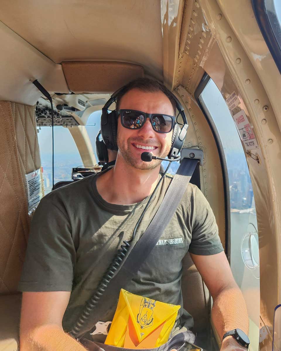 Daniel-smiles-at-the-camera-while-sitting-in-a-helicopter-over-Sao-Paulo