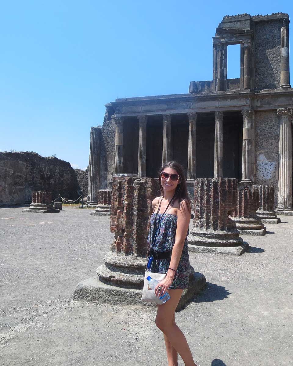 My-sister-poses-in-front-of-the-Pompeii-ruins-on-a-day-trip-from-Rome-Italy