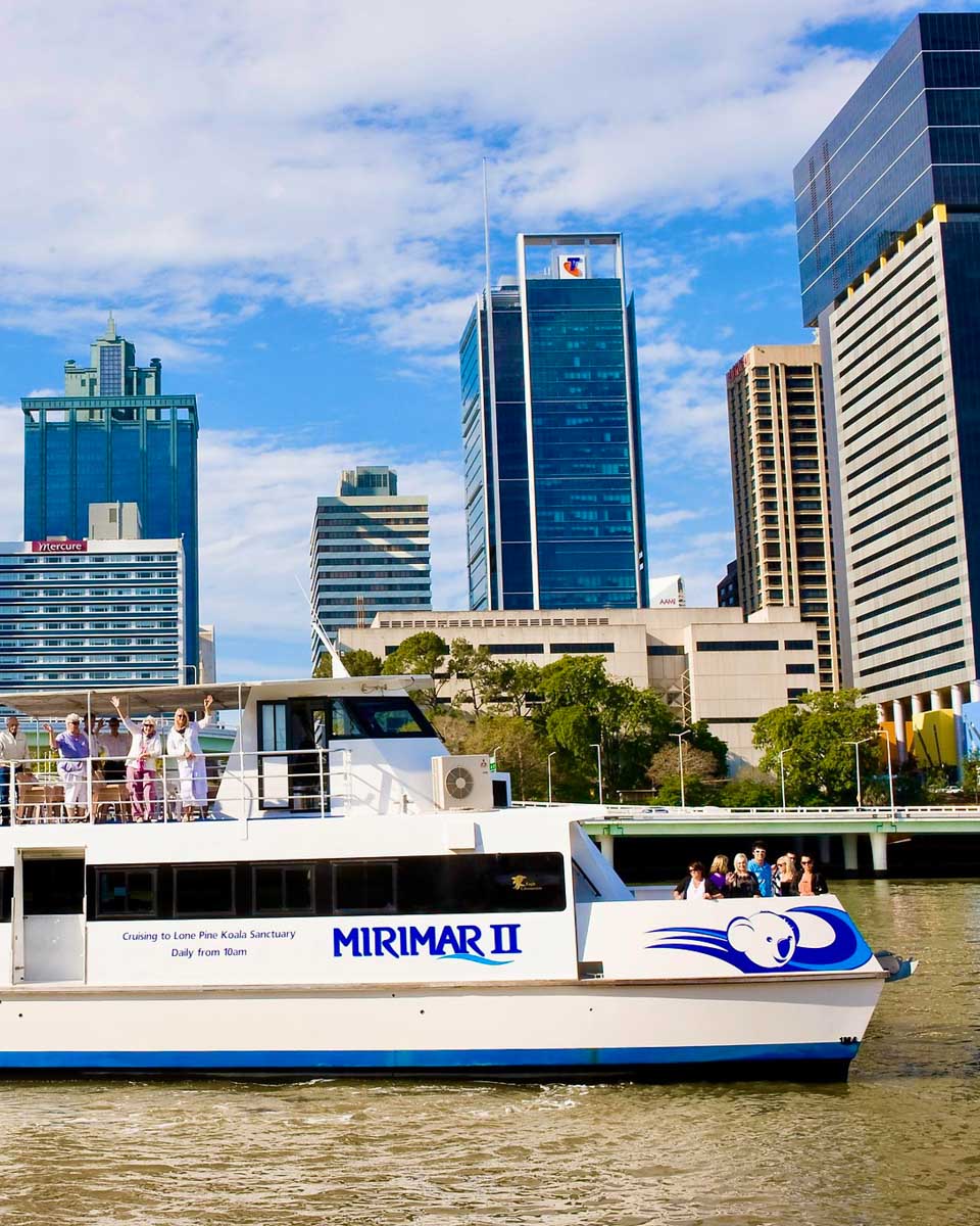 People wave on a river cruise with Koala and River Cruises in Brisbane