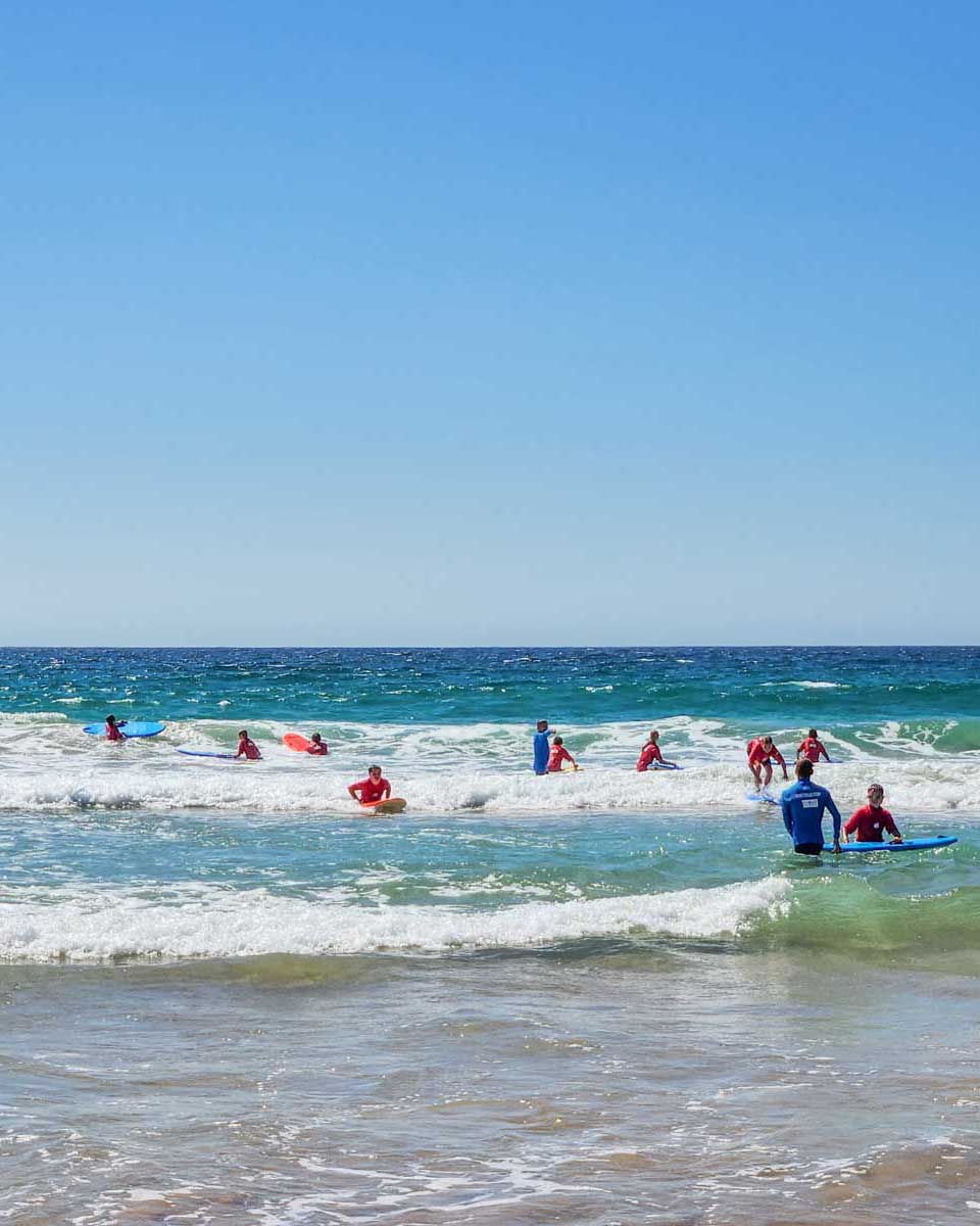A-group-of-people-learn-to-surf-in-Byron Bay Australia