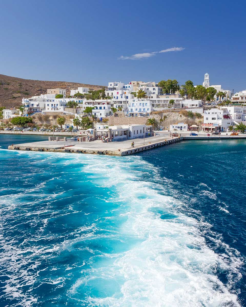 A boat ferry leaves Adamas in Milos Greece