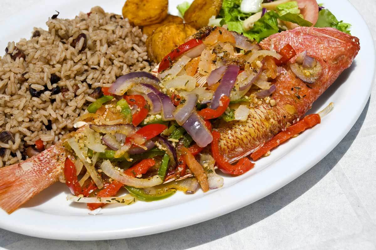 Pan Fried Red Snapper fish with Vegetables and Rice eaten in Belize City Belize
