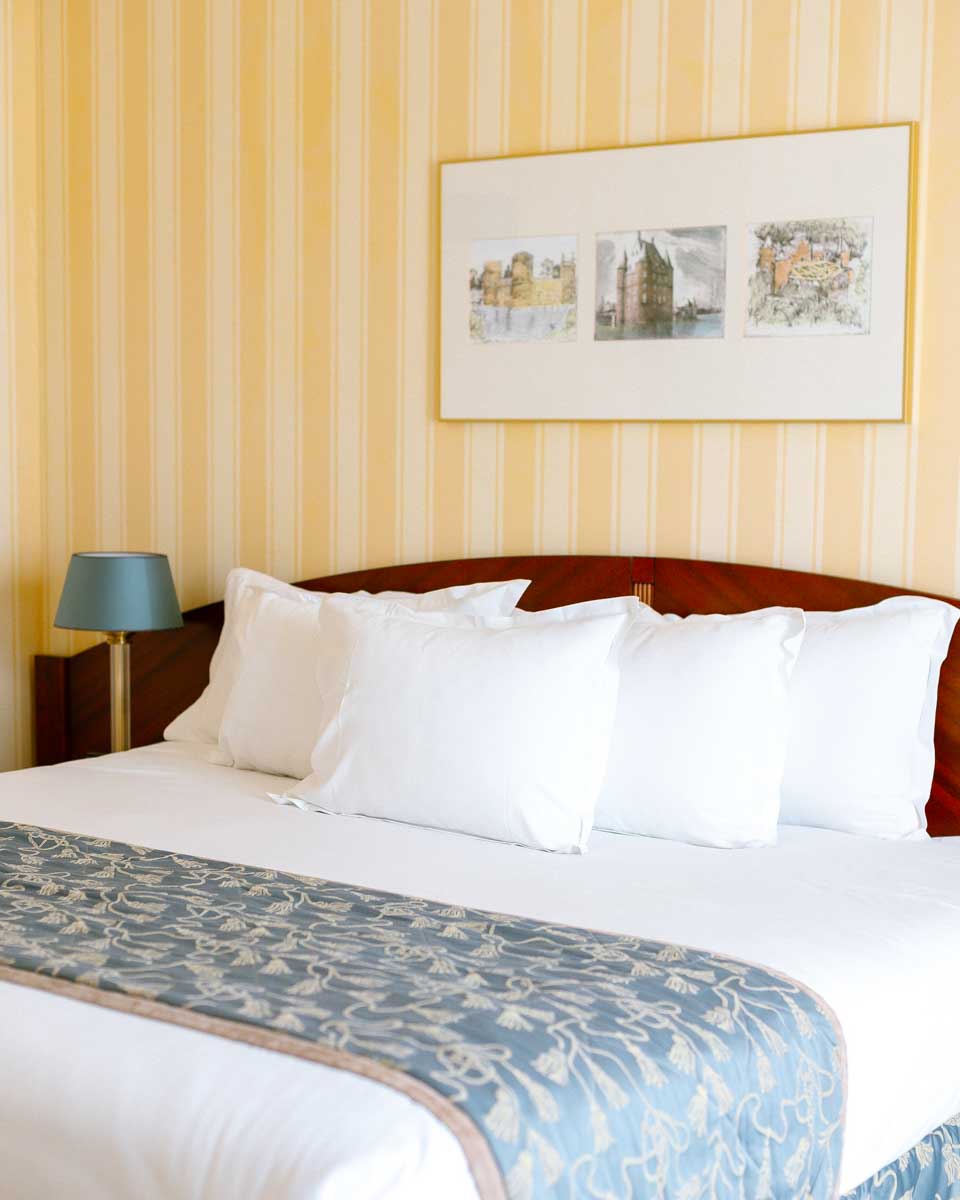 Bed in the hotel room at Hotel Le Châtelain in Brussels