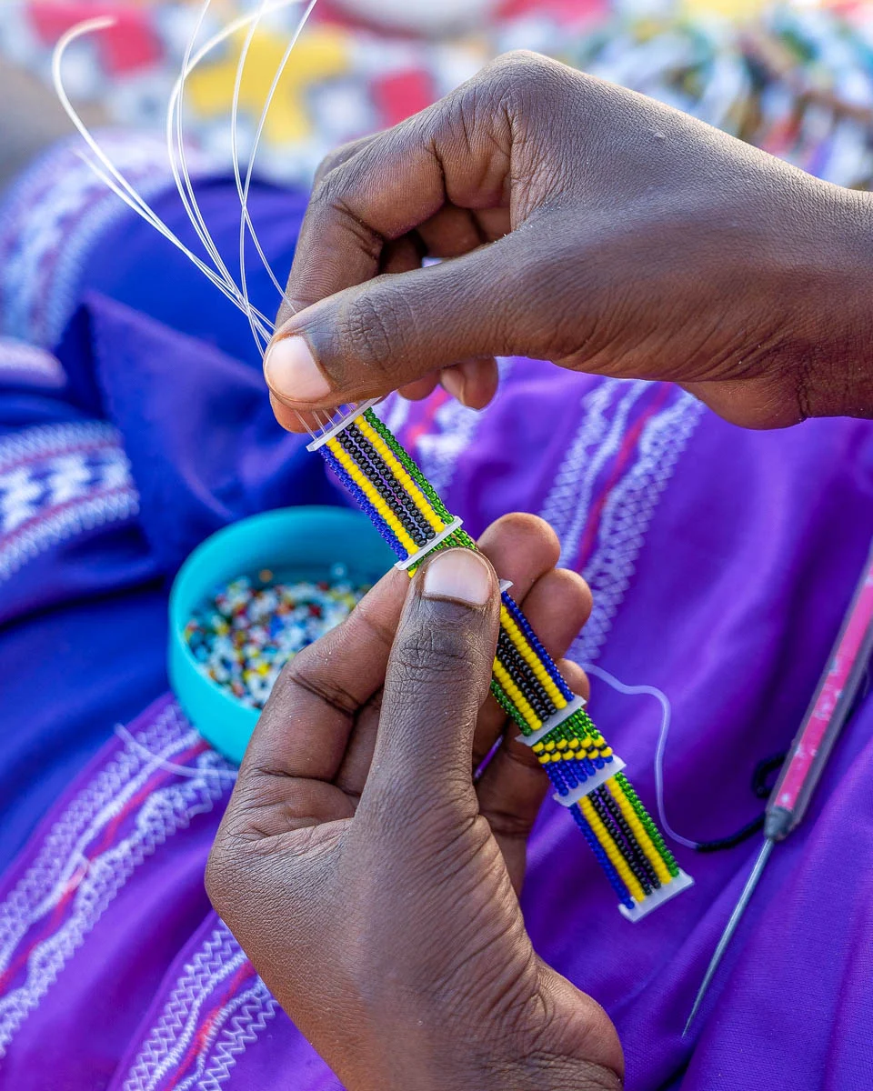 A-Massai-woman-making-jewelry-at-a-market-in-Zanzibar-Tanzania