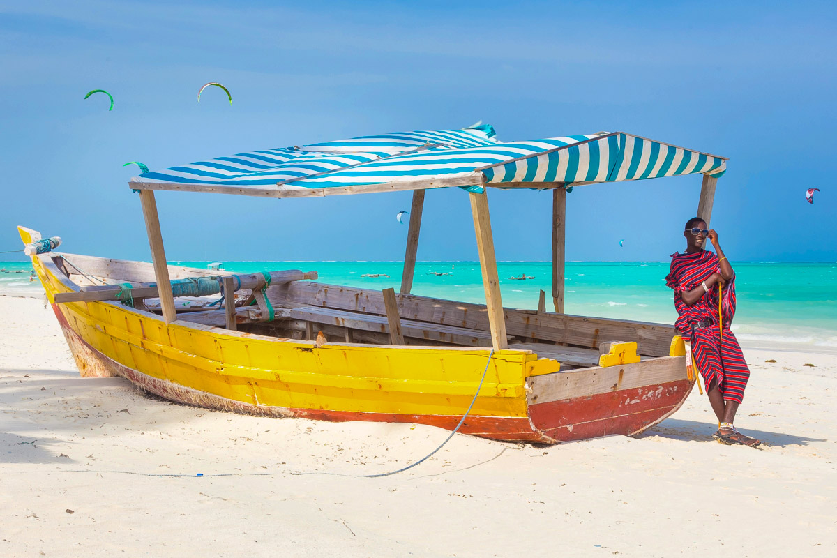 A-local-Maasai-man-stands-by-a-boat-on-the-beach-in-Zanzibar-Tanzania