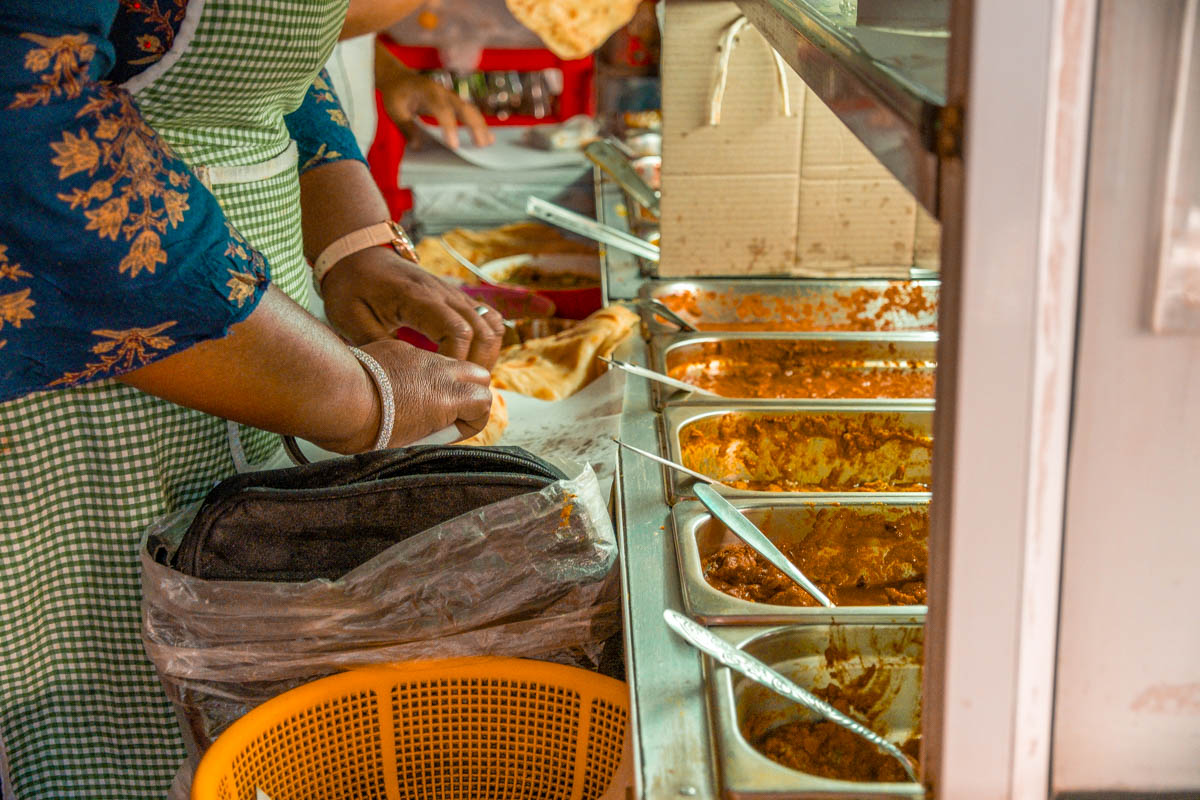 People prepare food on a food tour in Mauritius