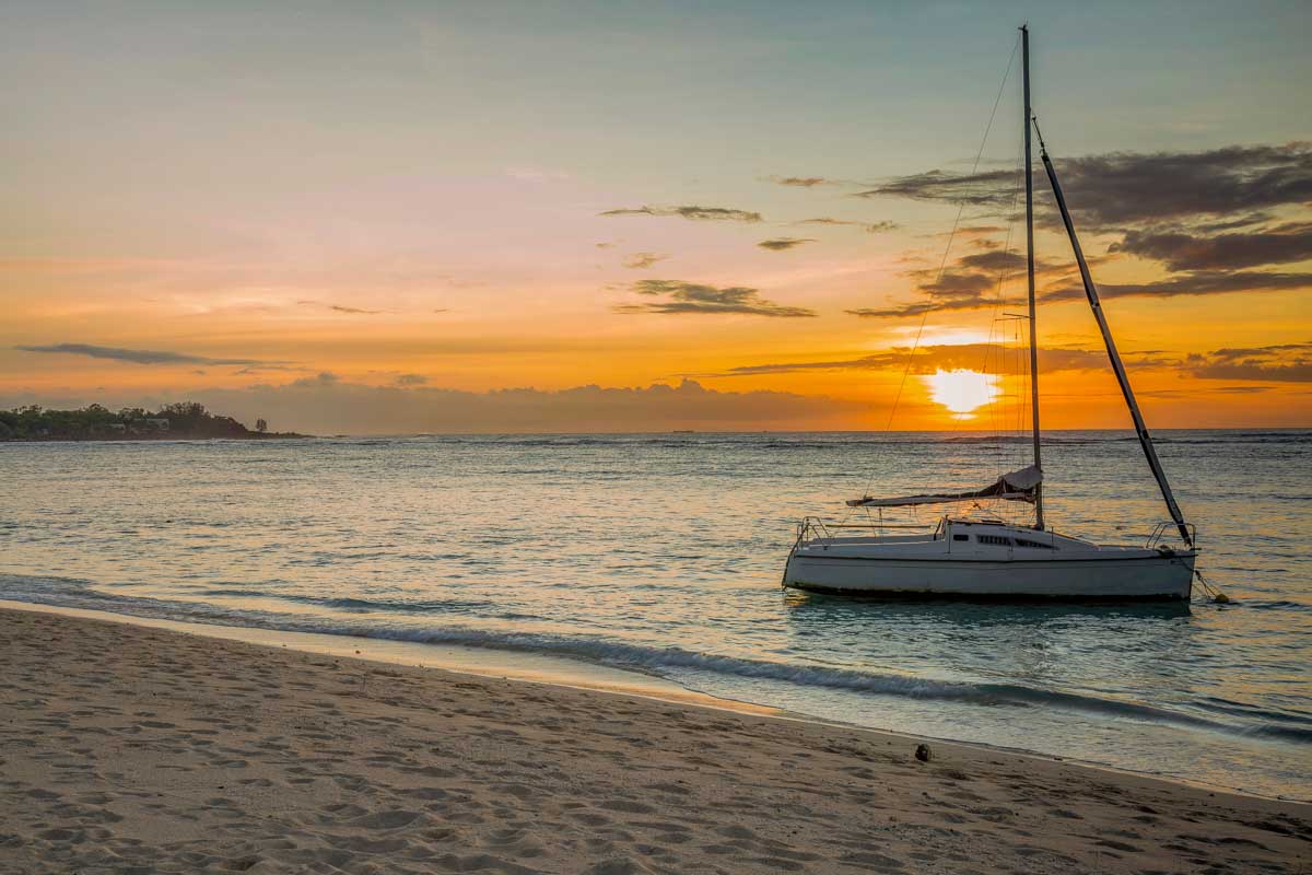 Sail boat at sunset on the public beach of Albion in West Coast Mauritius